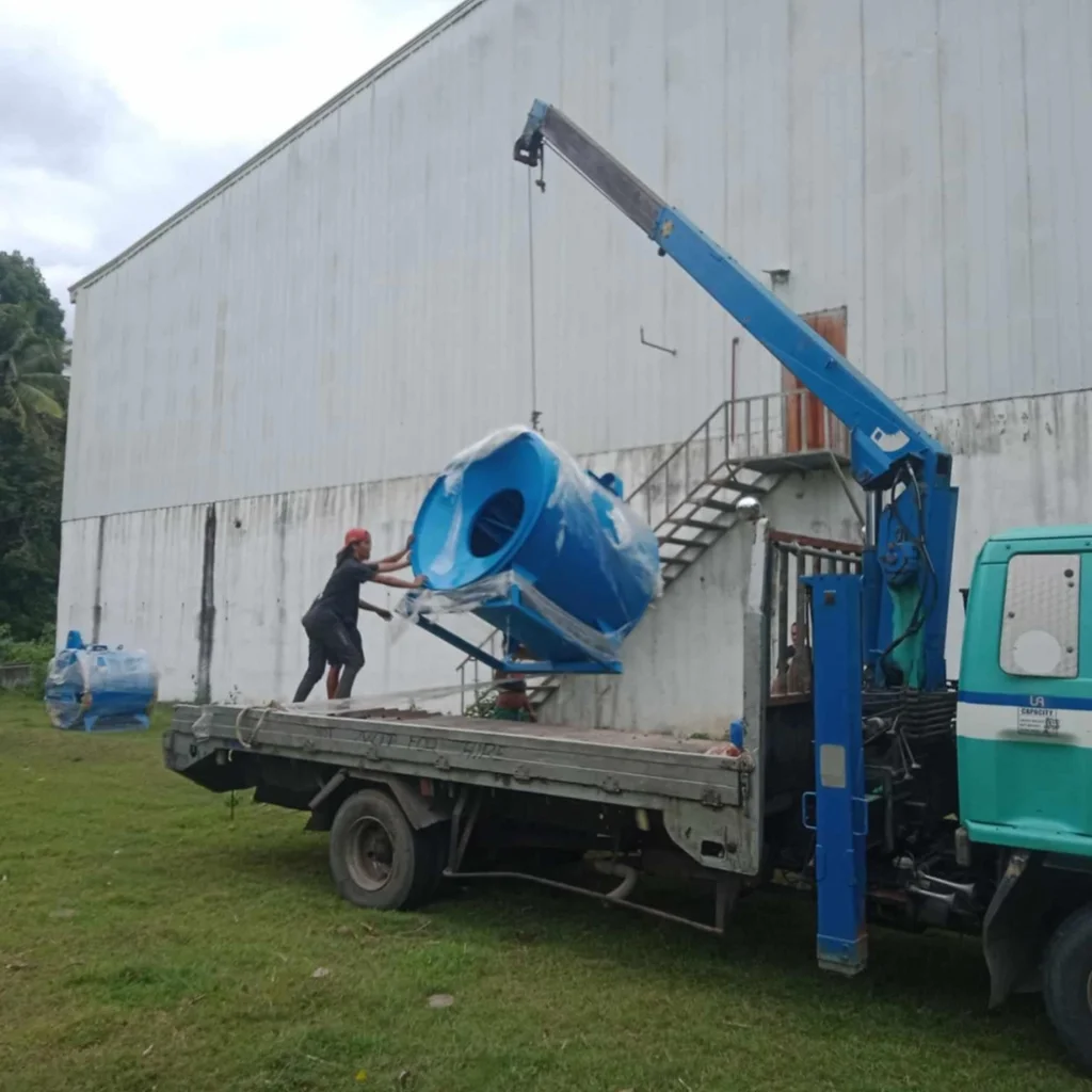 Mechanical and Electrical Engineering workers using a crane to unload Smoke Extraction Blower