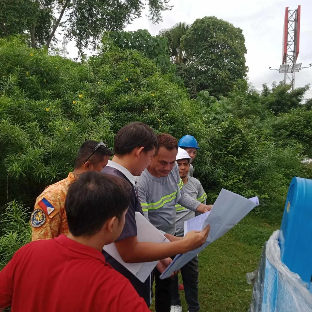 Mechanical and Electrical Engineering workers reviewing blueprints for smoke extraction blower